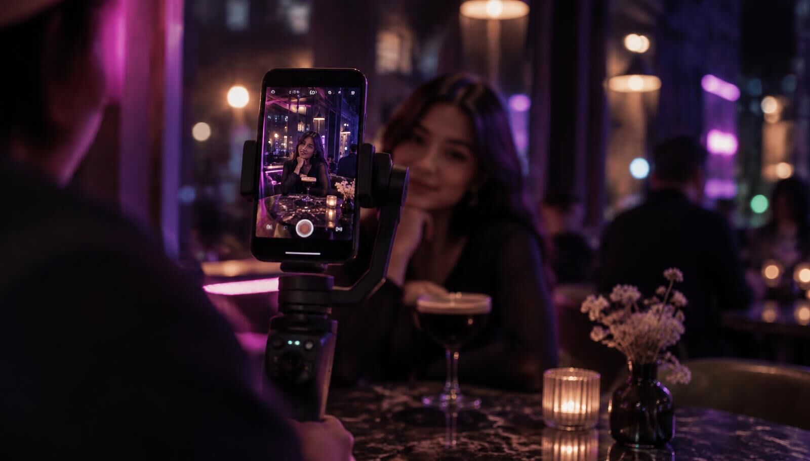 Smartphone on a gimbal filming a vertical reel inside a cafe lit with purple neon light